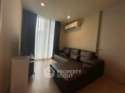 Modern living room with sleek leather sofa and air conditioning, featuring floor-to-ceiling window.