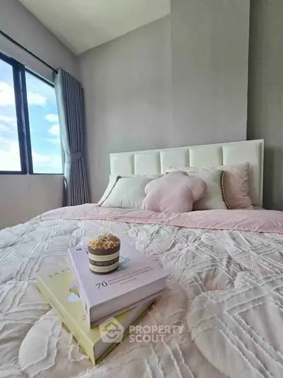 Cozy bedroom with plush bedding and large window offering natural light and scenic views.
