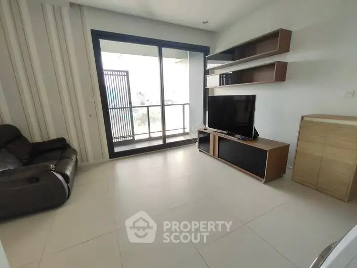 Modern living room with sleek furniture and balcony access in a stylish apartment.