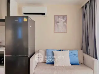 Modern living room with sleek fridge and cozy sofa, perfect for urban living.