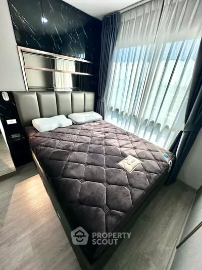 Luxurious bedroom with plush bedding and floor-to-ceiling windows for natural light.
