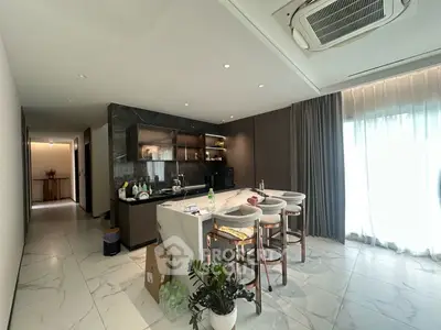 Luxurious modern kitchen with marble island and stylish bar stools in a spacious open layout.