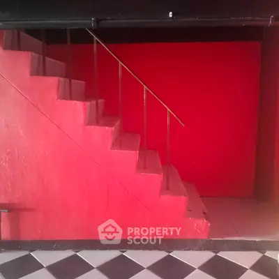 Bold red staircase with geometric black and white floor tiles, modern interior design