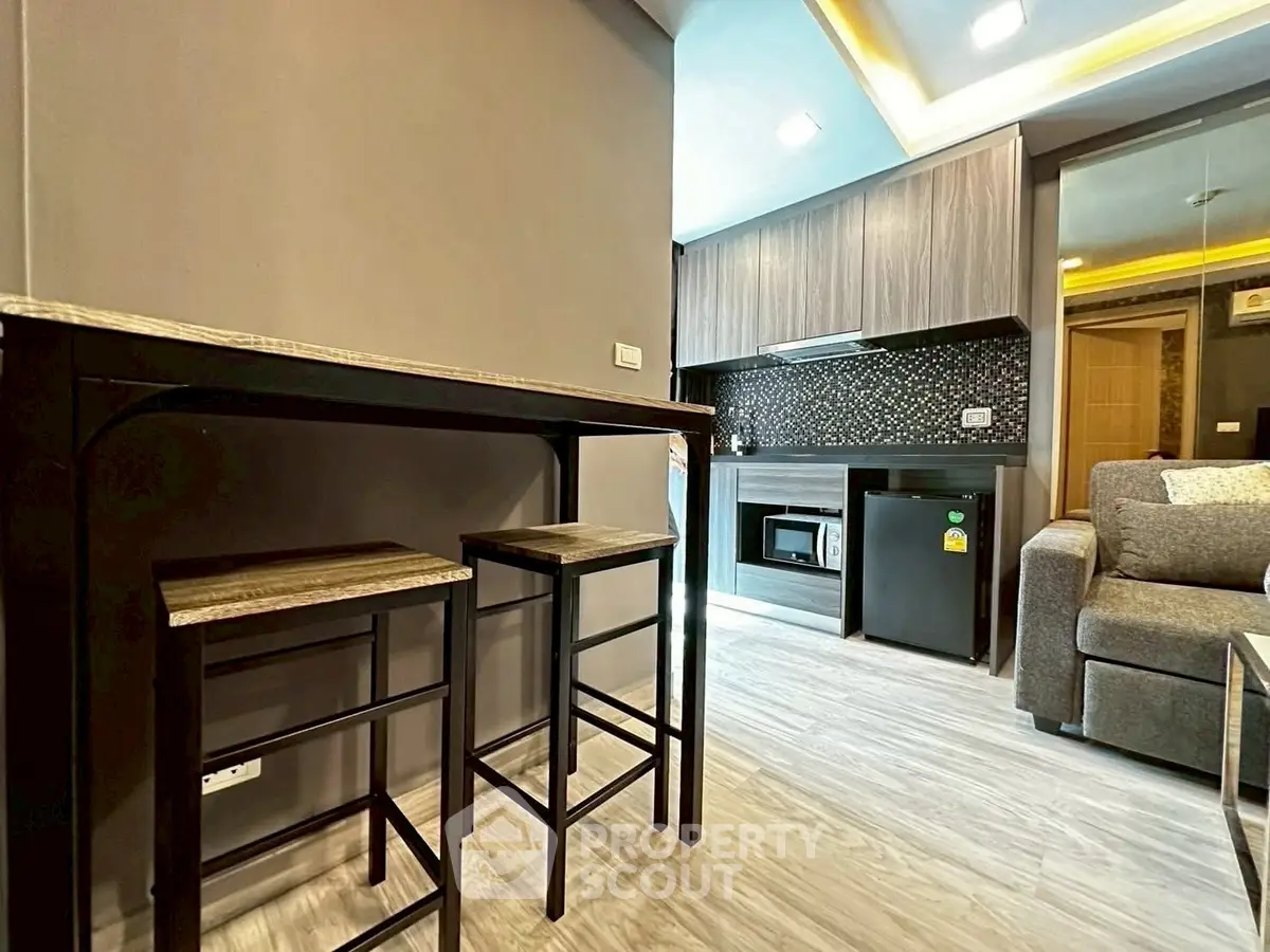 Modern open-layout kitchen with stylish bar stools and cozy living area.