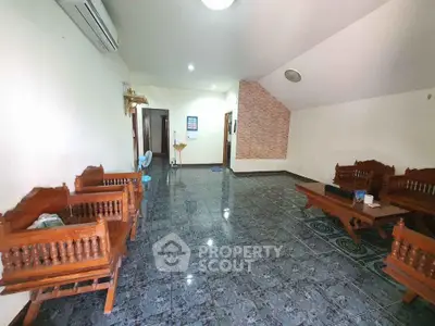 Spacious living room with traditional wooden furniture and tiled flooring