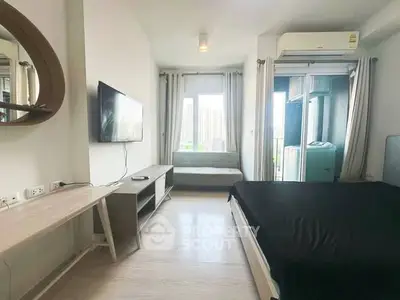 Modern bedroom with city view, featuring sleek furniture and natural light.