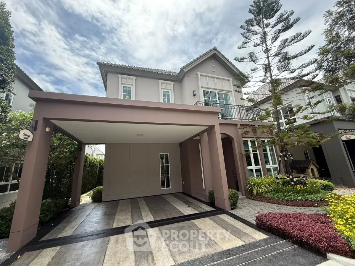 Elegant two-story house with spacious carport and lush garden in a serene neighborhood.