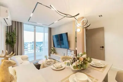 Modern living room with elegant dining area and large TV, featuring stylish lighting and panoramic windows.