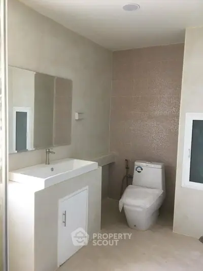 Modern bathroom with sleek fixtures and neutral tones, featuring a spacious layout and contemporary design.