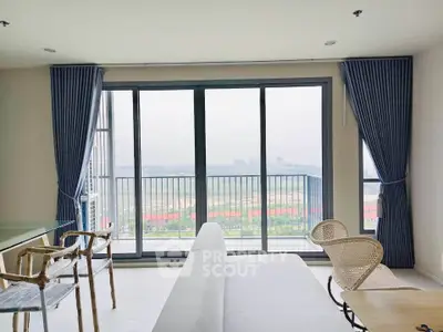 Spacious living room with floor-to-ceiling windows and stunning balcony view.