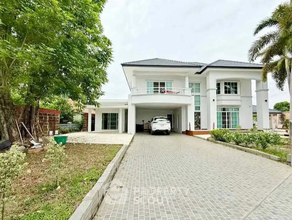 Stunning modern two-story house with spacious driveway and lush greenery.