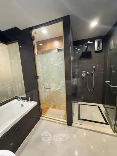 Luxurious modern bathroom with glass shower and bathtub in elegant apartment.