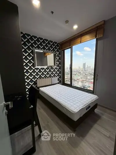 Modern bedroom with city view, stylish decor, and large window for natural light.