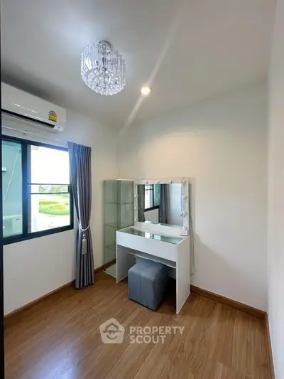 Chic and cozy bedroom with elegant vanity and natural light, perfect for a serene retreat.