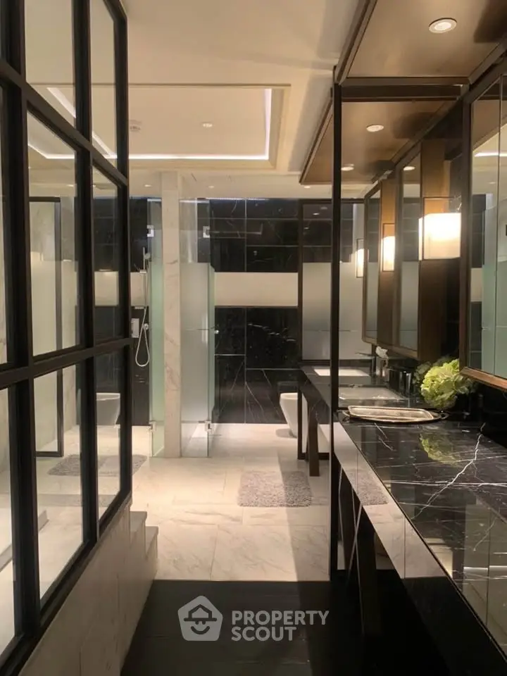 Luxurious modern bathroom with marble countertops and glass shower enclosure