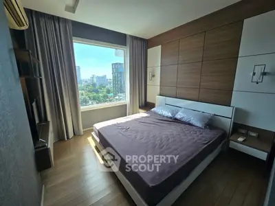Modern bedroom with large window and city view, featuring sleek design and natural light.