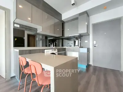 Modern kitchen with sleek cabinetry and dining area in contemporary apartment.