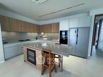 Modern kitchen with sleek island, built-in oven, and gas stove in a stylish open layout.