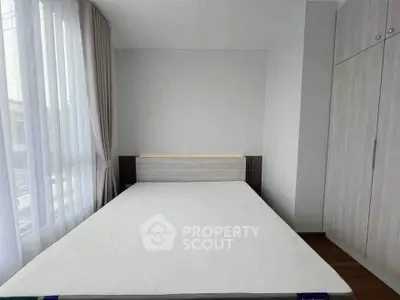 Modern minimalist bedroom with large window and built-in wardrobe