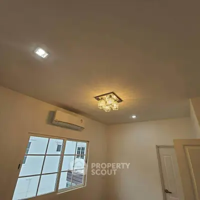 Modern interior room with elegant ceiling light and air conditioning unit, showcasing a bright and cozy atmosphere.