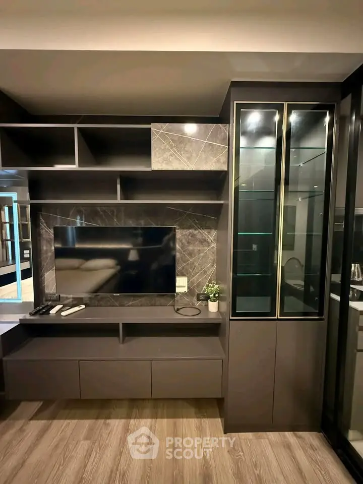 Modern living room with sleek TV unit and glass cabinet, perfect for stylish urban living.