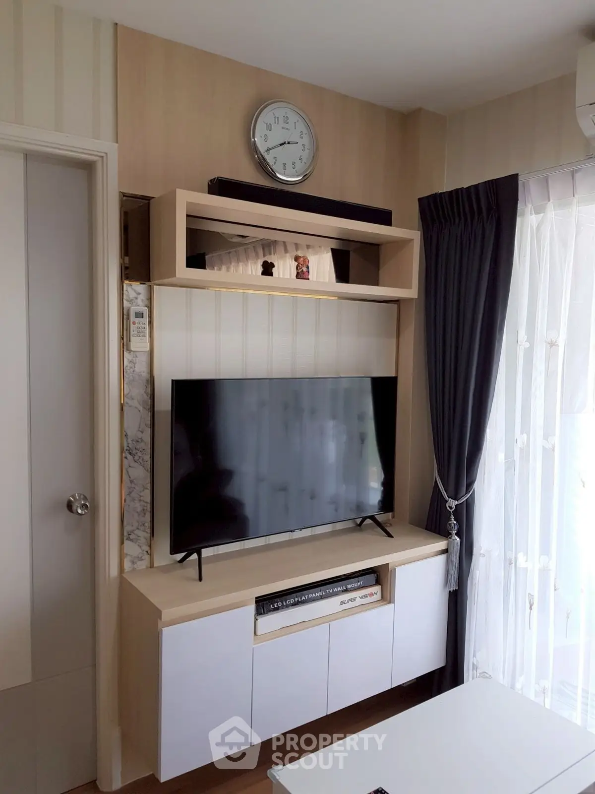 Modern living room with sleek TV setup and elegant curtains