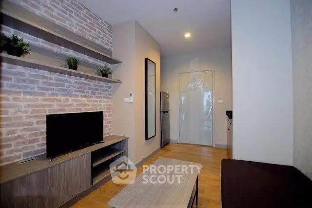 Modern living room with brick accent wall and sleek furniture in a cozy apartment.