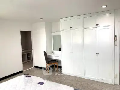 Spacious bedroom with built-in wardrobe and cozy vanity area, perfect for modern living.