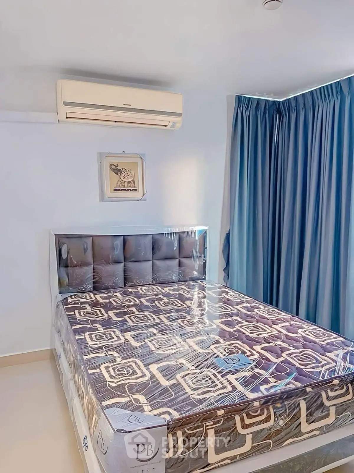 Modern bedroom with stylish bed and air conditioning, featuring elegant blue curtains and contemporary decor.