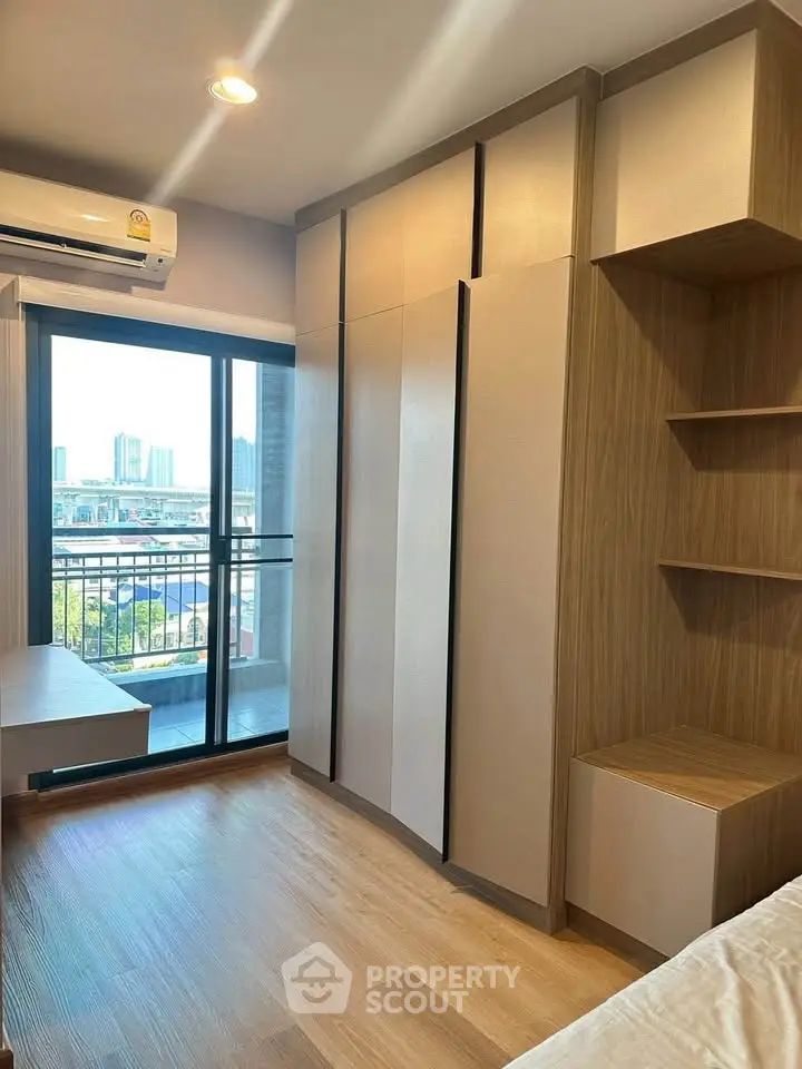 Modern bedroom with built-in wardrobe and balcony view in urban apartment