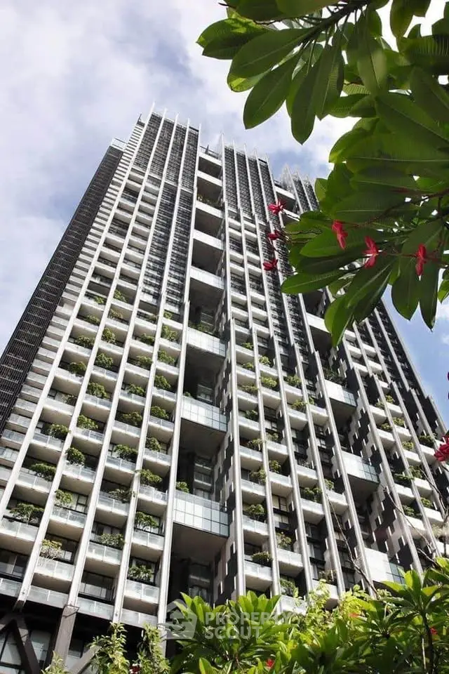 Stunning modern high-rise building with lush greenery and spacious balconies.