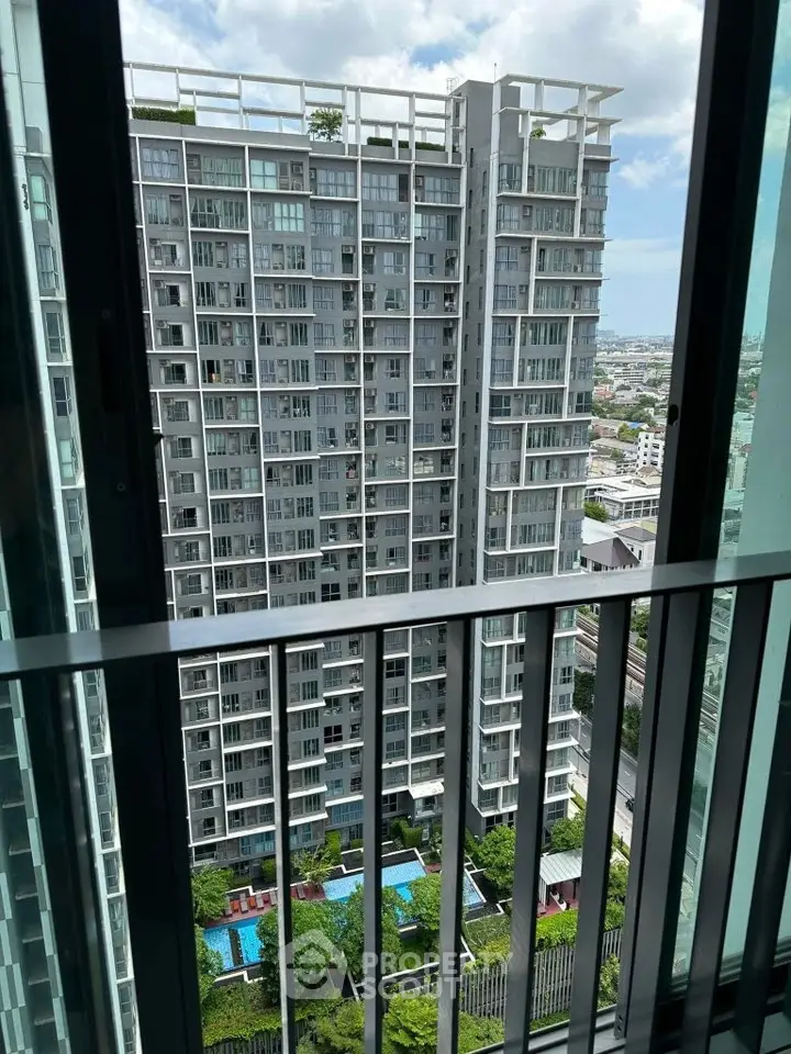 Stunning high-rise building view with pool and cityscape from balcony.