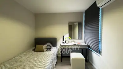 Cozy bedroom with modern decor and natural light, featuring a single bed and stylish desk.