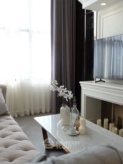 Elegant living room with modern decor, featuring a plush sofa, marble coffee table, and large TV.