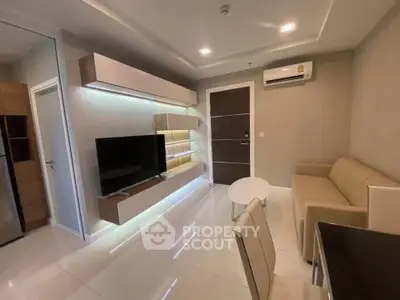 Modern living room with sleek furniture and ambient lighting, featuring a wall-mounted TV and air conditioning.