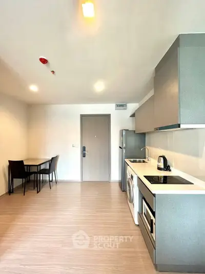 Modern kitchen with sleek cabinetry, integrated appliances, and dining area in a stylish apartment.