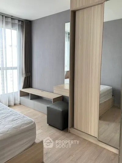 Modern bedroom with large window and stylish wooden furniture