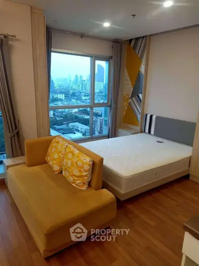 Modern bedroom with city view, featuring cozy sofa and stylish decor.