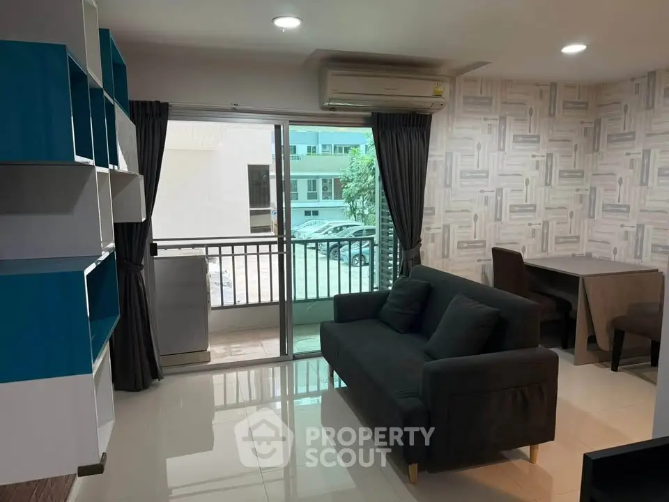 Modern living room with balcony access and stylish decor in urban apartment.
