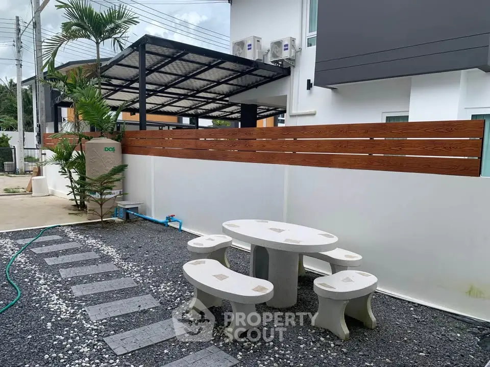 Modern outdoor patio with stylish seating and privacy fence in a contemporary home setting.