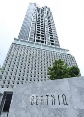 Stunning modern high-rise building with unique architectural design and lush greenery.