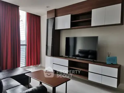 Modern living room with sleek TV unit and red curtains in a stylish apartment.