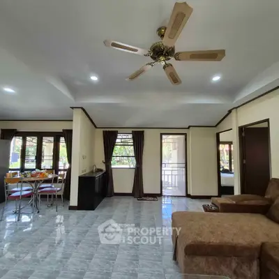 Spacious living room with ceiling fan and modern furniture in a bright open layout.