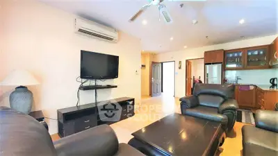 Spacious living room with leather sofas and modern kitchen in open layout