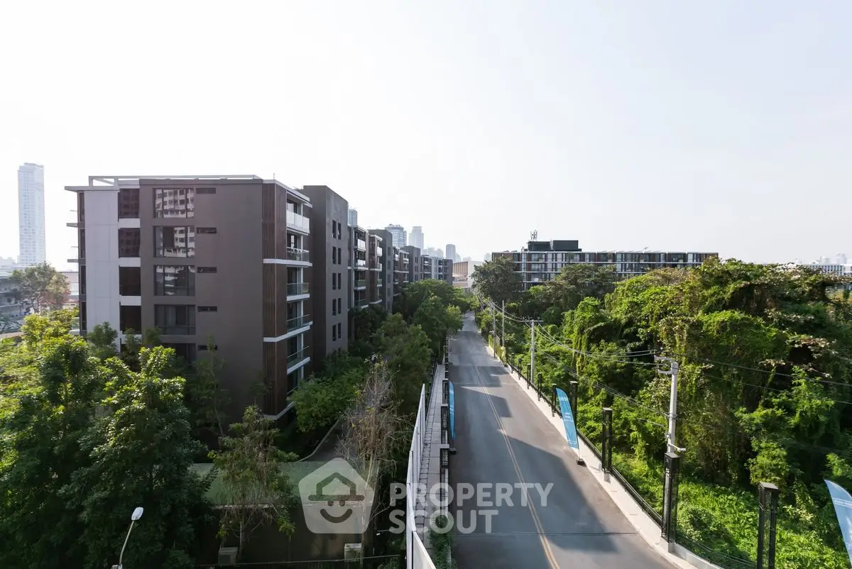 Stunning urban view from a high-rise building showcasing lush greenery and modern architecture.