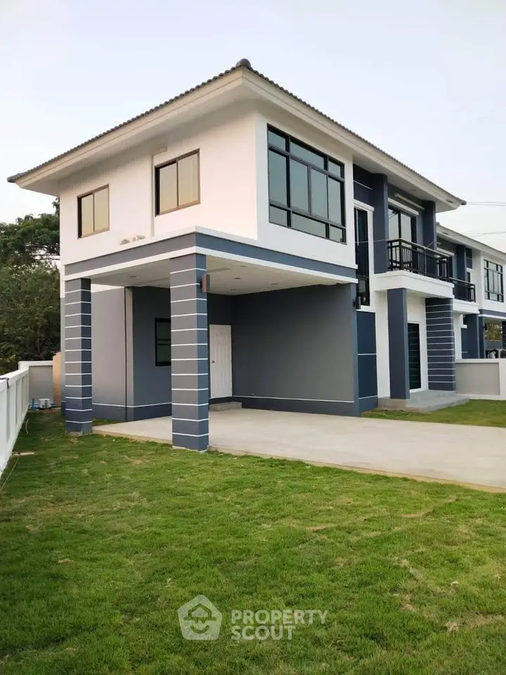 Modern two-story house with sleek design and spacious lawn, perfect for family living.