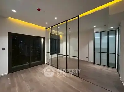 Modern apartment with sleek glass partitions and ambient lighting
