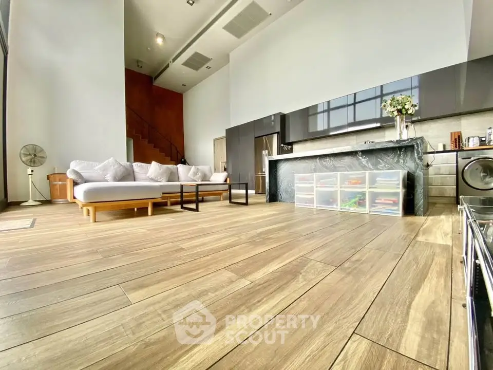 Spacious modern living room with open kitchen and high ceilings