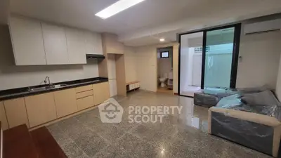 Spacious modern living room with open kitchen and large sliding doors to patio.