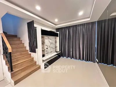 Modern living room with sleek staircase and elegant curtains